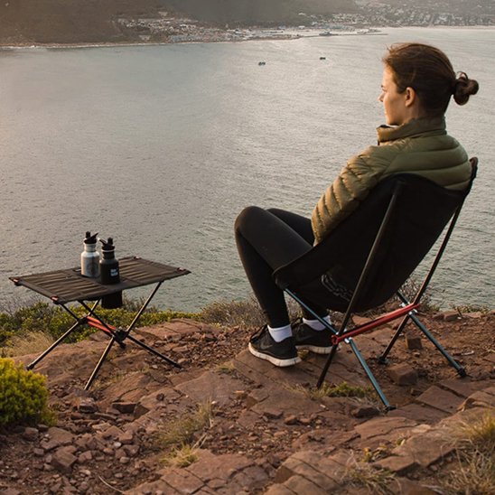 Chaise de camping a dossier haut sur le bord d'une rivière