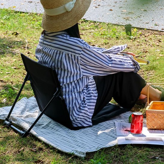 Chaise de camping avec femme assis sur le bord de la riviere