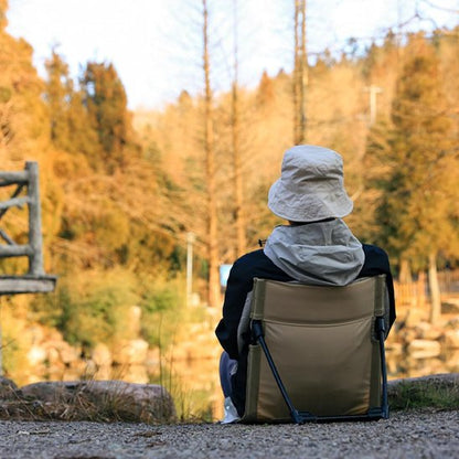 Chaise de camping avec une personne qui pêche sur le bord de l'eau