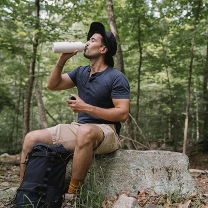 Gourde isotherme Homme assis sur roche buvant de l'eau