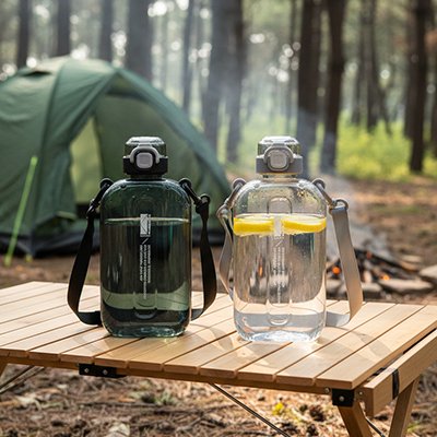 Gourde plastique 2 bouteilles sur une table  en camping